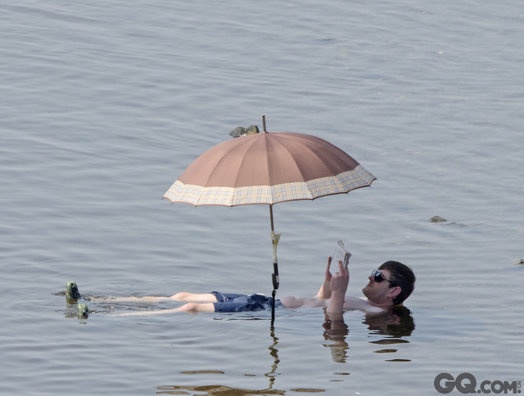 德国德累斯顿，一名男子躺在浅浅的河水中，降温解暑。   