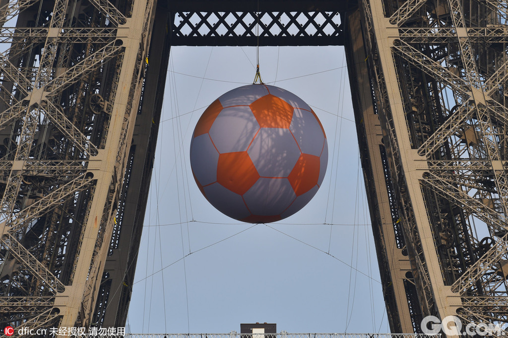 法国巴黎，2016年欧洲杯前瞻，埃菲尔铁塔下悬挂巨型足球，静候欧洲杯开幕。