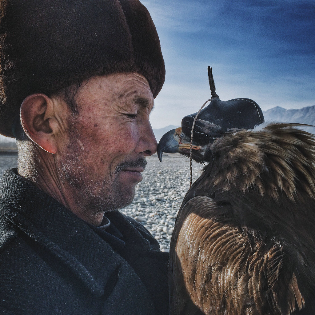 NO.2今年的大奖花落中国新疆
年度最佳摄影师大奖由来自中国新疆的牛思源获得，获奖作品为《老人与鹰》。“英勇智慧的柯尔克孜人生活在新疆南部的山脉中，世代与鹰为伴。他们把鹰当作自己的孩子，并常年驯服雄鹰来帮自己捕猎。老人今年 70 岁，在家人和朋友面前，他是一位刻板、威严的长者，但当他和心爱的鹰在一起时，嘴角会不经意的上扬。当鹰到了繁育年龄，尽管老人万分不愿，还是要放鹰回到山里，让它们去繁衍后代。老人饱经风霜的面庞下，一颗温柔的心，一份细腻的爱，一览无余地展现出来。所谓铁汉柔情，说的就是这位老人吧。”