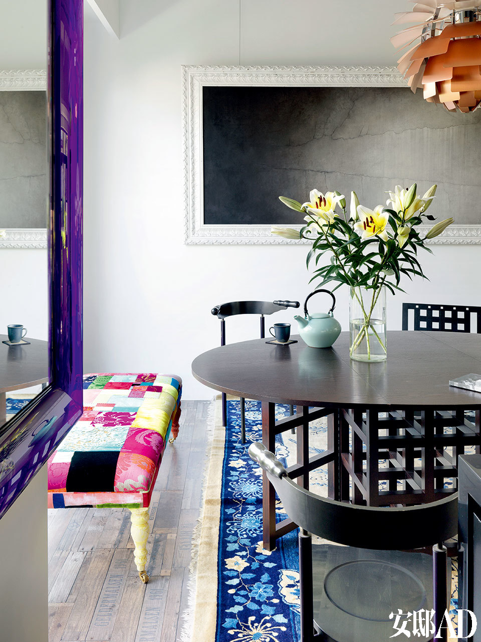 墻上掛著陳文驥的極簡風格畫作，正契合姚謙現在追求的的氛圍。用餐空間，黑色餐桌餐椅為查爾斯·馬金托什(Charles Rennie Mackintosh)的作品，一旁彩色拼布榻為設計師Lisa Whatmough為倫敦品牌Squint所設計。墻上是藝術家陳文驥的作品《漸離》。