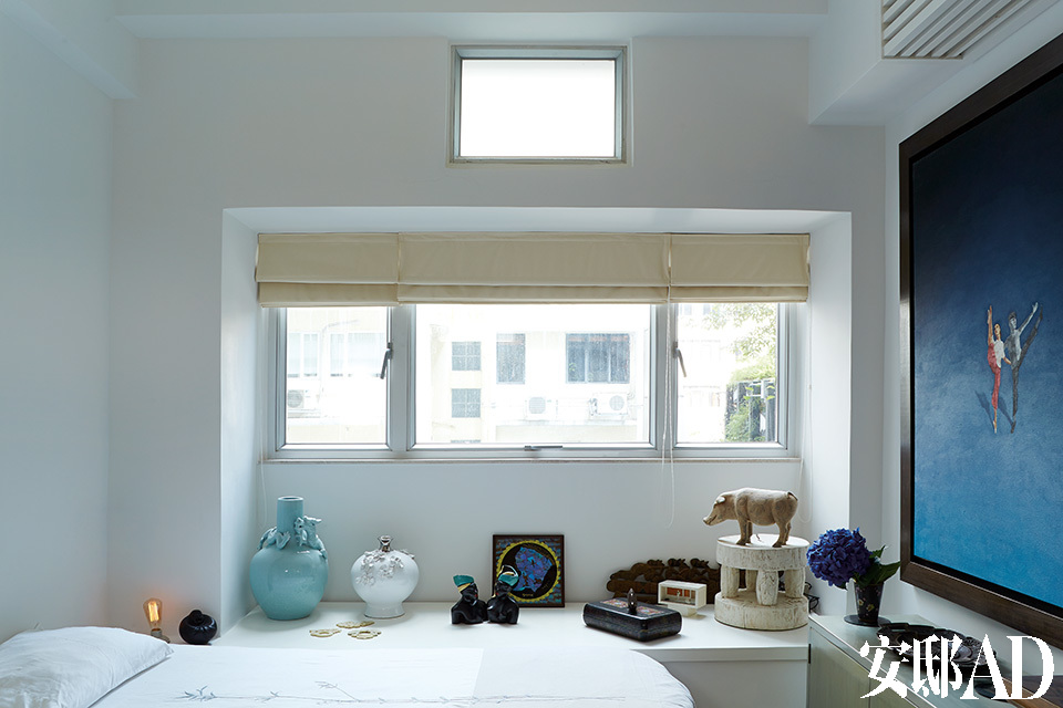 小小的卧室空间安静而素雅，墙面和床上用品都选择了白色，各类中式古玩与一幅刘坤的大型油画营造出一种与世隔绝的静休氛围。
