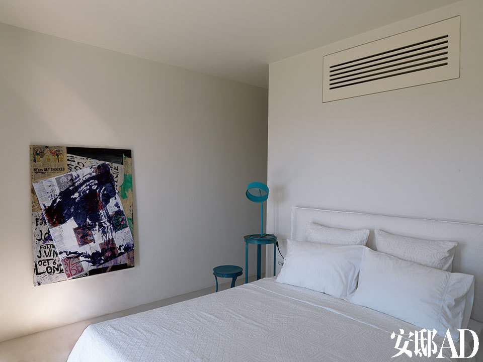 另一间卧室中，细脚伶仃的台灯、小几和偶尔出现的当代艺术画作，成为了让人眼前一亮的点滴色彩。墙上挂着一幅名为《无题》的混合材质拼贴画，由Josh Smith创作于2008年。