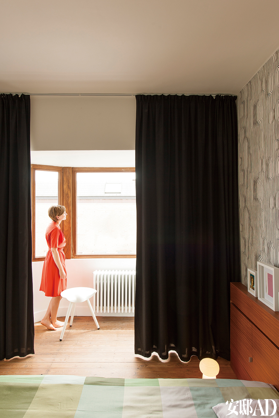 主卧室里，Frekvenssi的黑白壁纸来自Marimekko，与房间的大面积白色形成反差。床头板用来存书，十分实用（由GRAUX & BAEYENSArchitecten设计）。绿色Hay床品为纯色的卧室带来了一抹明亮的心情。