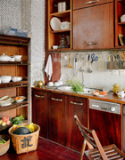 厨房与餐厅开放相连，碗柜和折叠凳是民国时期老上海的物件，购于高碑店古董家具市场。厨柜是用红花梨木定做的，吊柜为沙比利木，台面则为巴西花梨木。