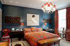 日理万机的生活步调，让羽西更懂得卧室与睡眠的重要。床头挂的画作来自中国年轻艺术家林海容。在这个家中能见到许多中国新生代艺术家的作品，也能看出羽西对其的支持；床一旁搭配的是16世纪来自北京的木制家具与热带风格的成套窗帘、床组在深蓝色墙面的调和下，显得很有特色。