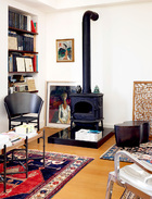 书房位于3层，棕黑色角椅是Philippe Starck的设计，调色盘陶几来自Ligne Roset。角落里的两幅油画均来自台湾油画家陈来兴。老窗花片来自苏州，是清代的老件。波斯地毯来自土耳其，是1980年的产品。