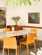 满室绿植生机盎然，令中式与西式、艺术与家具和谐对话。餐厅的一侧，墙上的画作来自Onofre Frias，
餐桌上的布朗库西（Brancusi）雕塑摆件依然是来自古根海姆博物馆的复刻品。