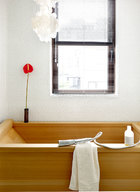 一個砌滿白色馬賽克的浴廁，浴缸為手工特別定制，使用特殊的阿拉斯加扁柏木材質。