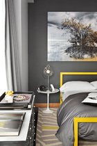 “我们想要一间黄色调的客房，这幅摄影作品终于成为串联整个空间的线索。”客房，床头挂着一幅摄影师Isack Kousnsky的照片，床架来自Room & Board，地毯来自West Elm ，床头夜桌来自Knoll，台灯为Artemide。