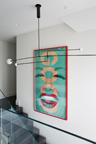 一处楼梯间挂着Michael Anastassiades设计的吊灯，墙上的作品来自北美概念艺术家Barbara Kruger。