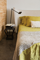 Cassina品牌的床、床品和床尾毯，一旁为Flos的Kelvin台灯。“你在这里可以接触到朝气，风动叶动更惹动了整个山景。”
