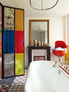 在家里给各种色彩找到合适的地方安身，哪怕是浴室的地砖都绝不能放过。镜子前是俄罗斯玩偶合辑，混凝土地砖来自巴黎的Petit Pan。