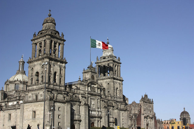 墨西哥大教堂（LaCatedraldeMexico）是墨西哥最大的和最主要的天主教堂，也是美洲屈指可数的著名教堂之一。位于墨西哥城索卡洛广场北侧。大教堂始建于1573年，1823年以后才正式完工，历时250年，堪称美洲建筑历史之最。这是一座由玄武岩和灰色沙质石料砌成的巨大建筑物，教堂呈传统的拉丁十字形布局，有一个中殿和两个侧殿。与中殿成十字形交叉的侧殿中，设有许多小祭坛和7个小教堂。其中一些小教堂都是后来各个不同艺术派别的艺术家们不断加工和改建的。皇家祭坛（或称皇家小教堂）是整个教堂中最漂亮的建筑。祭坛装饰极端讲究，为丘里格拉建筑艺术中的珍品。祭坛顶部的穹窿，镶嵌着各种金银珠宝和高贵华丽的雕饰，半圆形壁龛上布置了精致复杂的精美雕塑，还有20幅宗教绘画，全是墨西哥著名的画家何塞•罗德里格斯•华雷斯的杰作。这个祭坛主要为朝拜圣母的教徒而设。祭坛上有一尊非常漂亮的用象牙雕塑的基督受难像，纯银十字架，抛光蹭亮。小教堂内还安放着殖民时期一些西班牙总督的遗骨。教堂的正面揉合了多种不同建筑艺术风格，灰色的墙面映在白色的大理石上，给人一种和谐与庄重的感觉。高耸的一对塔楼是新古典派建筑，内置最大的钟，称瓜达卢佩圣马利亚钟。此钟1792年铸成。底部直径3米，高5米，约12吨重。钟声敲响，10千米外都可听见。两座塔楼的顶部，各有一个巨型的石制十字架。在教堂正门的外围有一道13米长、7米高的铁栅栏。据说此乃金、银、铜的合金制品。是当时的墨西哥总督从澳门的一个葡萄牙商人手中弄来的中国产品。与教堂正面并排耸立的教堂礼拜堂正门，也是珍贵的巴洛克式建筑，墙壁上布满了细腻豪华的雕塑，壁柱上也有姿态生动的雕像和各种各样的装饰图案。