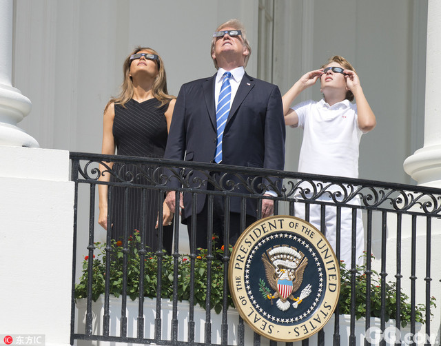 美国华盛顿，美国总统特朗普携妻子梅拉尼娅、女儿伊万卡和儿子巴伦等人在白宫阳台上观看日全食。