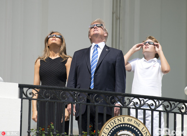 美国华盛顿，美国总统特朗普携妻子梅拉尼娅、女儿伊万卡和儿子巴伦等人在白宫阳台上观看日全食。