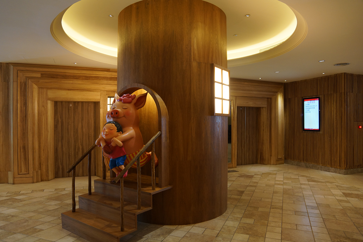 走进饭店大厅柜台旁的大圆柱，经过设计转化，正瞥见拥抱小男孩的粉红猪，成为另一个惊喜；
