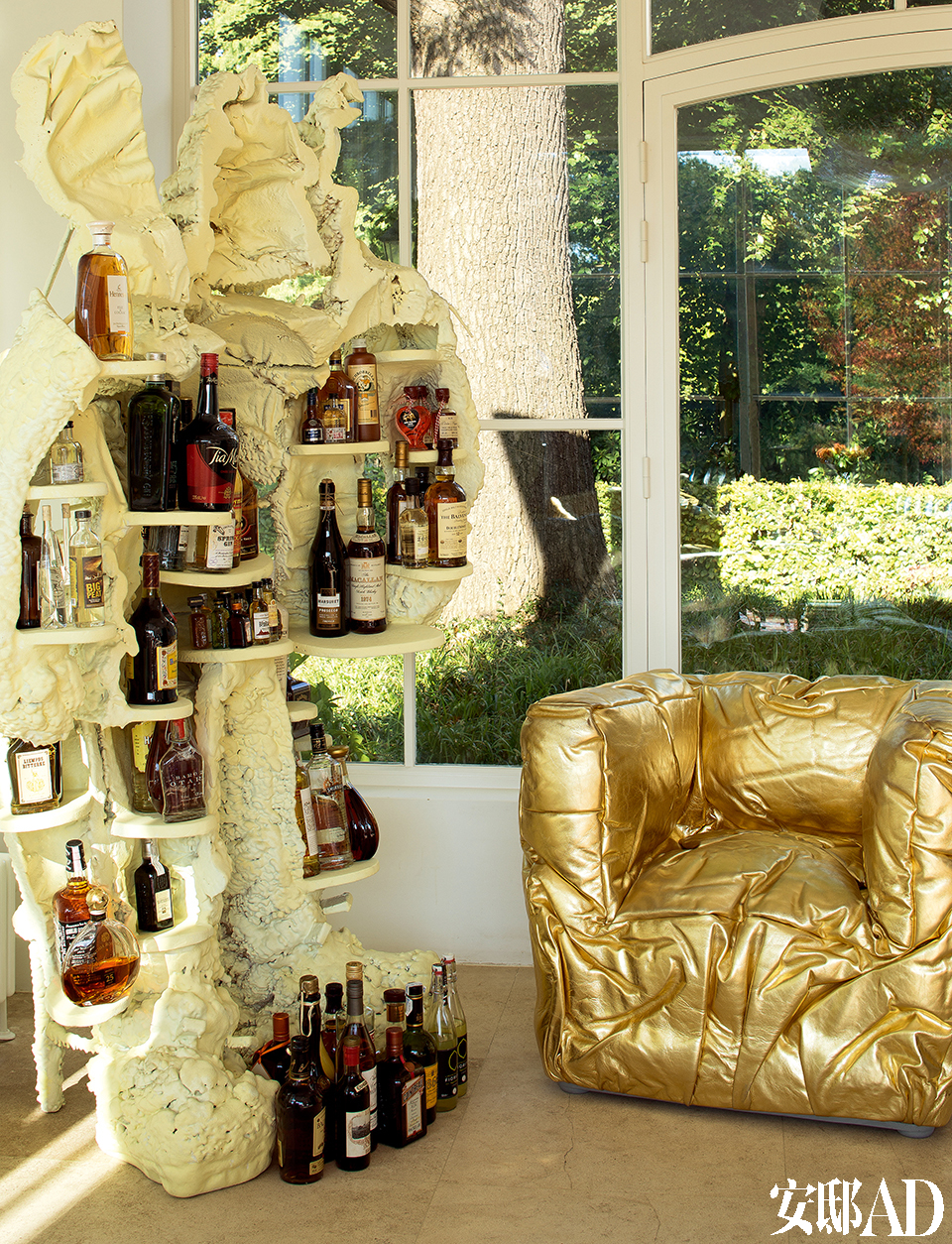 客厅里的金色沙发呼应着满室阳光，空间因此被点亮。艺术家创作的人形柜子用来存酒，生活本就该如此随性！用来存酒的人形柜子是荷兰艺术家Joep van Lieshout创作的Humanoid系列作品。