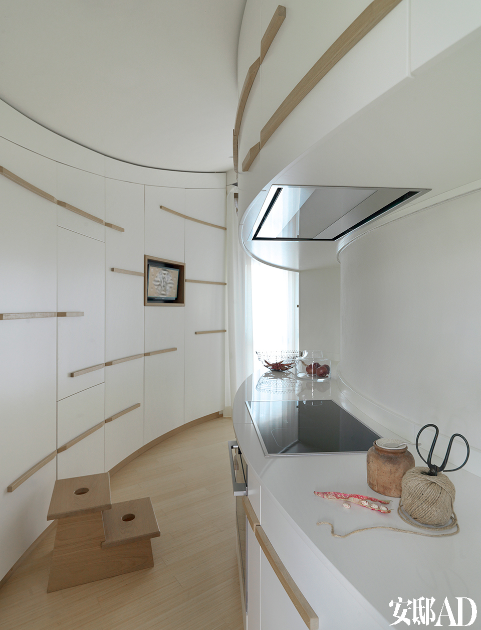 两位设计师攻克了厨房内弧形线条的设计挑战，为单调的墙壁注入了动感的韵律。弧形的厨房给两位设计师带来了一定的挑战，设施来自Miele，木制的小梯凳是设计师自己定制而成的。