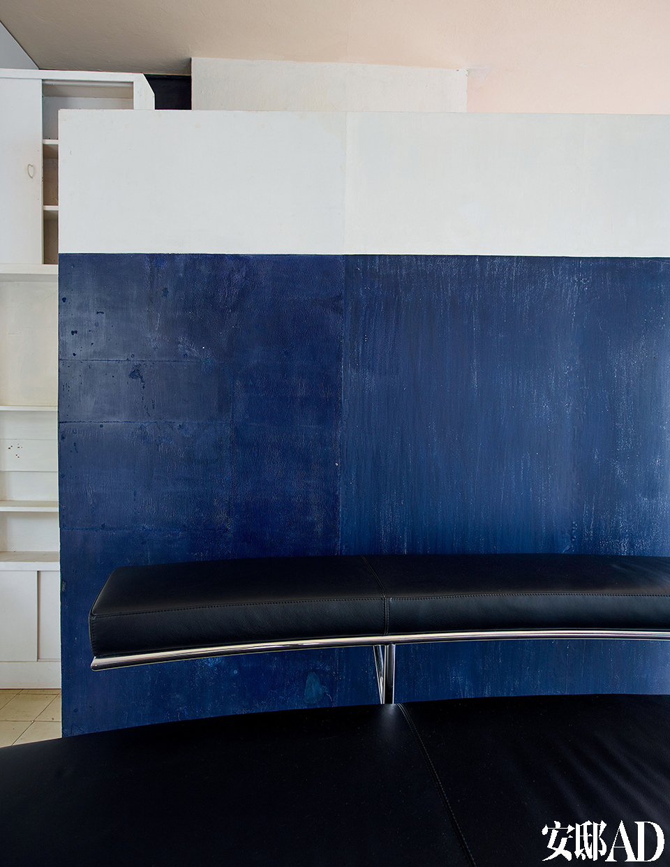 绘画室的一角，蓝色的墙面前摆放的是Eileen Gray设计的座椅。