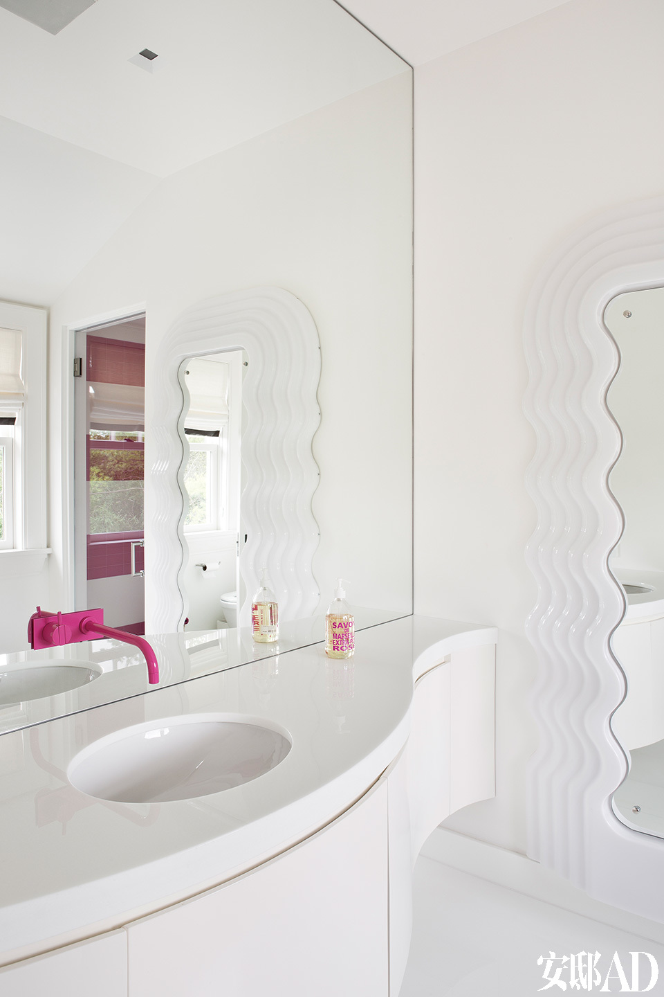 更衣室旁边的卫生间也延续着粉红元素，镜子来自Ettore Sottsass。