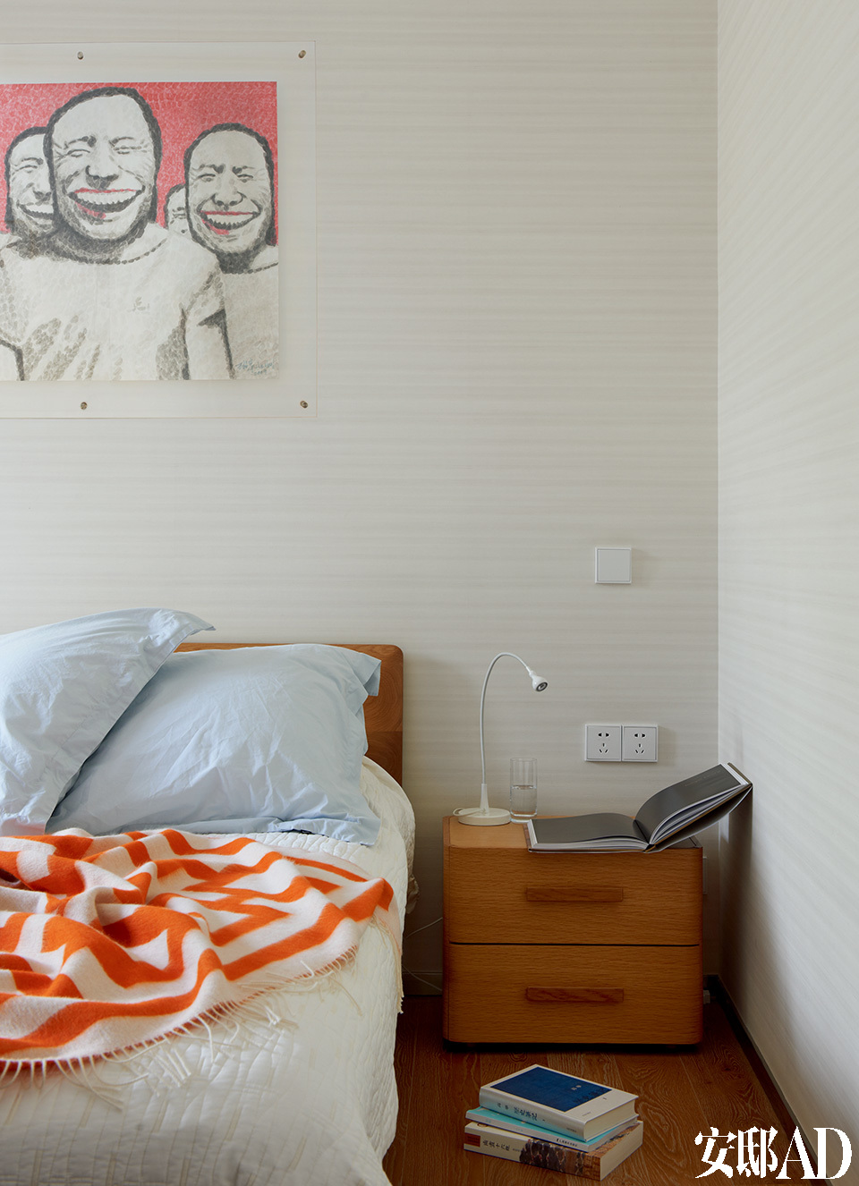 主卧室中，墙上的画作是艺术家韩湘宁的纸上作品，床头柜由日本设计师创作，床上的橘红色几何盖毯来自Lane Crawford连卡佛。