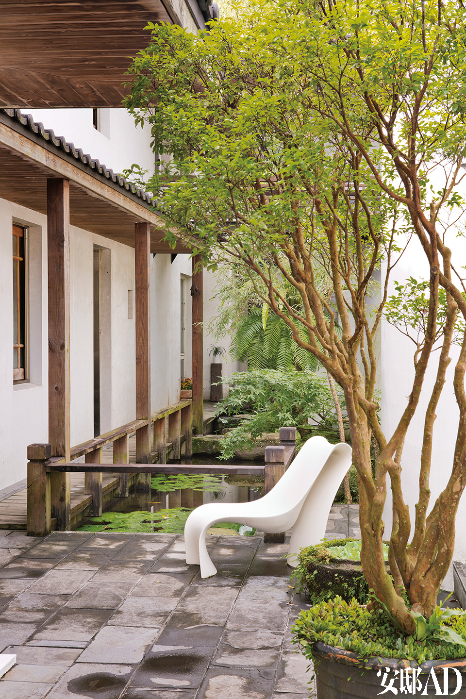 林宪能在原有的建筑物上加建木头回廊及一座流水造景，配上品牌Zanotta的白色户外椅，显现出现代江南园林的精神。