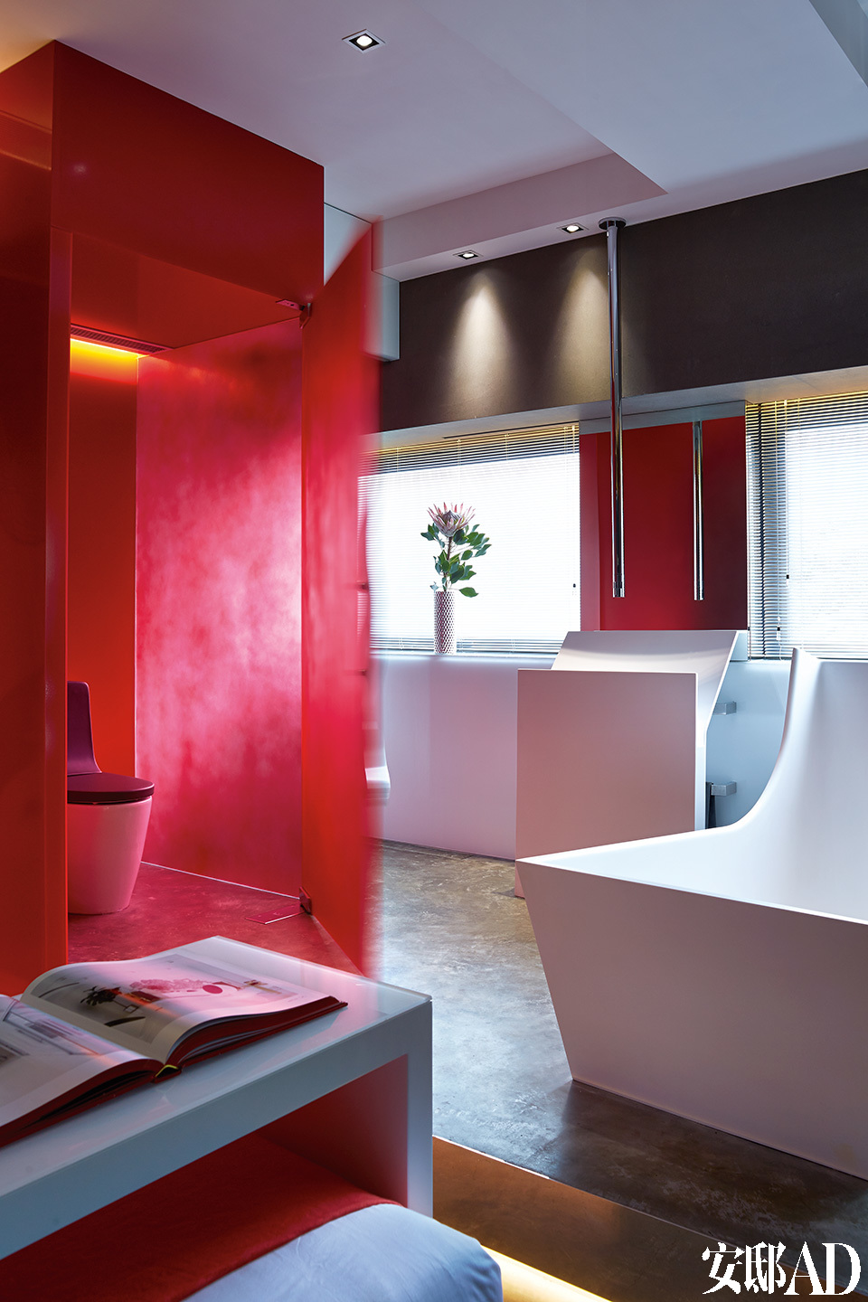 超现代的浴室里雕塑般的浴缸、面盆及水管都出自Antonio Lupi 为Tuscany设计的卫浴系列。红色马桶间的门把手由Philip Watts设计。开放式卫浴就嵌在卧室里面，浴缸与洗手盆仿佛两件雕塑，为空间添色不少。
