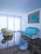 意大利“冰激凌女王”Sandra Vezza几年前买下了著名设计品牌Gufram 。早就是Gufram铁粉、一直喜欢艺术与设计的她，在自己的家里，更一直玩着现代碰撞传统的混搭游戏。一旁的单人椅是Studio 65在1972年设计的，墙面的湿壁画名为Summertime ，是Valerio Berruti在2013年创作的；配套的Summertime沙发椅也是Valerio Berruti在2013年为Gufram设计的作品。
