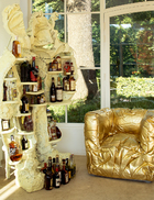 客厅里的金色沙发呼应着满室阳光，空间因此被点亮。艺术家创作的人形柜子用来存酒，生活本就该如此随性！用来存酒的人形柜子是荷兰艺术家Joep van Lieshout创作的Humanoid系列作品。