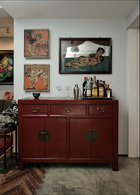 客厅通向餐厅的过道，在这里传统中式家具和中西艺术品搭配得恰到好处，红色漆柜起着餐柜的作用。