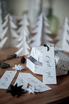 客厅的木制滚轮小桌上摆放着白色的手工圣诞树和Ylva创作的艺术字母标签。