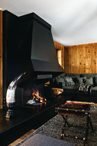 起居室的一侧有一个巨大的铁质壁炉，是Andy Kuchel专门为家里设计的。铁质壁炉突兀的线条，为整个空间带入摩登气息，同时又增加了环境的舒适度。