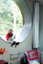 宽大的圆弧形窗沿为孩子提供了绝好的游乐空间，总是让小宝贝兴奋不已。儿童房的圆形窗户好像气泡一样，将窗外的森林美景圈进室内。