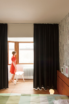 主卧室里，Frekvenssi的黑白壁纸来自Marimekko，与房间的大面积白色形成反差。床头板用来存书，十分实用（由GRAUX & BAEYENSArchitecten设计）。绿色Hay床品为纯色的卧室带来了一抹明亮的心情。